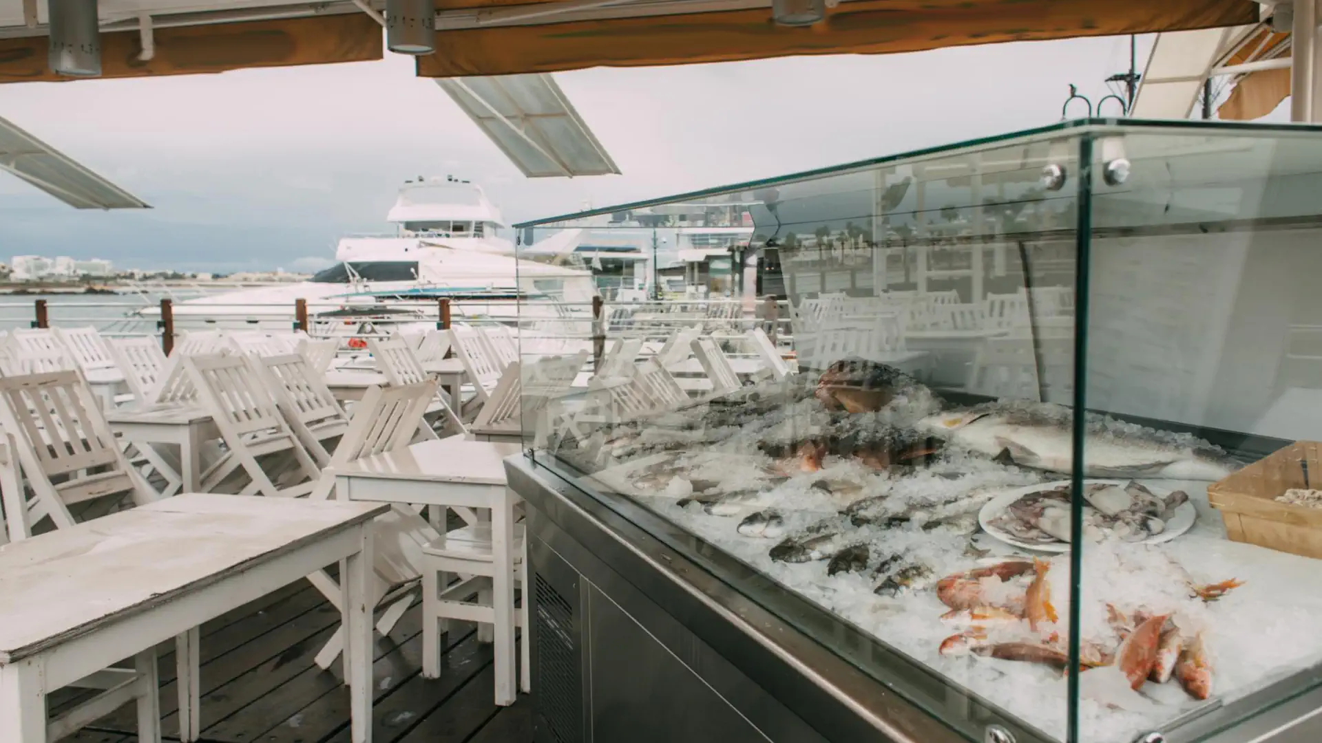 Zona social de un club náutico español con vistas al puerto deportivo